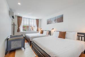une chambre avec deux lits et une fenêtre dans l'établissement The Urban478 Modern&Cozy Stay, à Bangkok