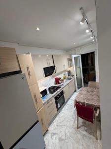 马拉喀什Résidence Soulaymane اقامة سليمان的厨房配有木制橱柜和桌子。