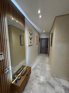 马拉喀什Résidence Soulaymane اقامة سليمان的一间设有走廊、桌子和镜子的客房