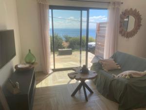 a living room with a couch and a view of the ocean at Chjama di mare in Santa-Maria-di-Lota +15 photos