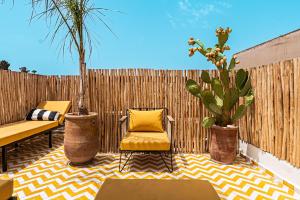 a patio with a chair and potted plants and a fence at Riad SASHA Exclusive&New Pool 6 pax Free Breakfast in Marrakech