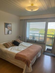 a bedroom with a large bed and a large window at Hotelli Terme 614 in Ikaalinen