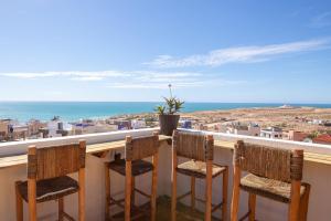 a balcony with chairs and a view of the ocean at Imsouane soul lodge in Imsouane