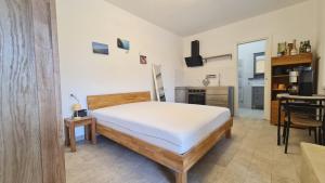 a bedroom with a bed and a desk and a kitchen at Coccinella studio apartment Le Valli in Pieve