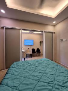 a bedroom with a large green bed and a desk at Clover Studiostay in Labuan