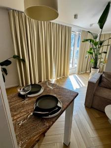 una sala de estar con una mesa con platos. en Piltza House, en Cracovia