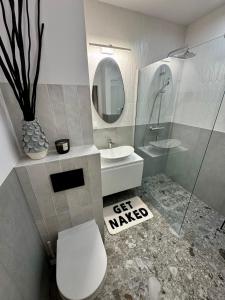 Un baño con inodoro, lavabo y espejo. en Piltza House, en Cracovia