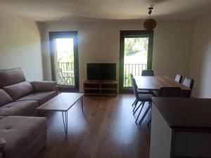 a living room with a couch and a table at Apartament FREIXE de Molló Parc in Molló