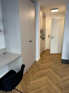 ベルリンにあるSkyline Apartment Adlershof - Premium Design and Full Kitchenの黒い椅子と廊下のある部屋 +11枚の写真