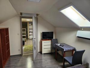 an attic room with a desk and a skylight at Comfy Attic Near the Airport - Full in Vecsés
