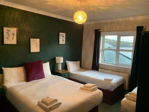 a hotel room with two beds and a window at Arch Guesthouse in Clifden