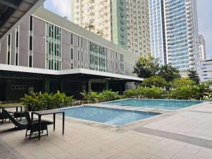 a large building with a swimming pool in a city at Louritto Studio Type Condo at Avida Towers Riala Tower 3 in Cebu City