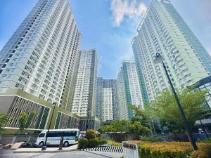 a bus is parked in front of tall buildings at Louritto Studio Type Condo at Avida Towers Riala Tower 3 in Cebu City
