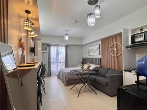 a room with a bed and a couch and a table at Louritto Studio Type Condo at Avida Towers Riala Tower 3 in Cebu City