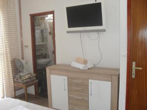 a room with a tv on a wall with a desk at Rooms Natalija in Sveti Juraj
