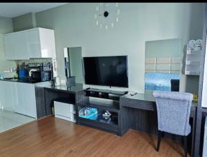 a living room with a television and a desk with a chair at Comfort Suite in Miri in Miri
