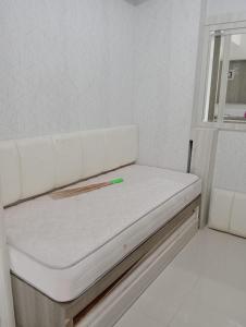 a white couch with a green pen on top of it at Green pramuka by Panda Room in Jakarta