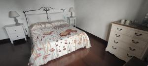 a bedroom with a bed and a dresser at Casa Cardea in Aprilia