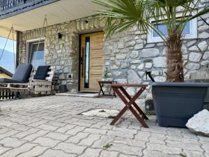 a patio with a table and chairs and a stone wall at Haus am Berch in Weissenstein