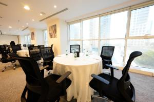 a conference room with a white table and black chairs at Myrtle AlSahafa Hotel فندق ميرتل الصحافه in Riyadh