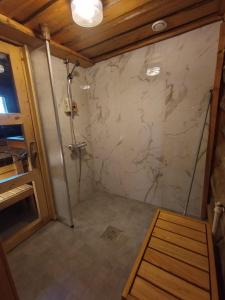a shower in a room with a marble wall at Chalet Luoston Lustitupa 3 in Luosto +28 photos
