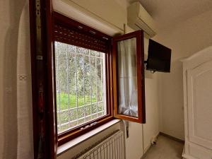 a window in a room with a radiator and a television at Charming Tuscany in Corsanico-Bargecchia