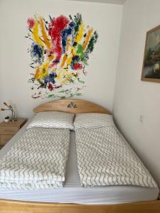 un letto in una camera da letto con un dipinto sul muro di Über den Dächern Ebnats ad Aalen