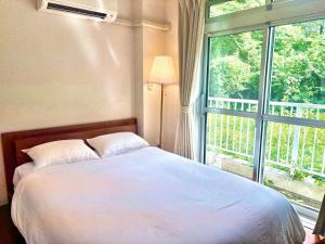 a bedroom with a bed and a large window at FujiteraCanvas102 in Gotemba