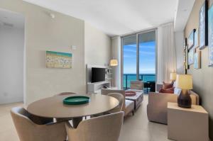 a living room with a table and a couch at Stunning Beach Front Condo Ocean View Pool Spa in Hollywood