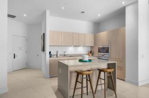 a kitchen with a island and two bar stools at Stunning Beach Front Condo Ocean View Pool Spa in Hollywood