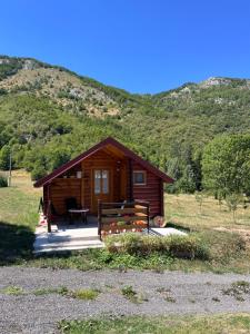 a cabin in a field with a mountain in the background at Wooden house in Šavnik
