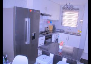 a kitchen with a stainless steel refrigerator and a sink at Elite Escape - 2 bedroom apartment in Avondale