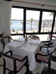 a dining room with a table and a view of the beach at Hostal S'Algaret in Fornells