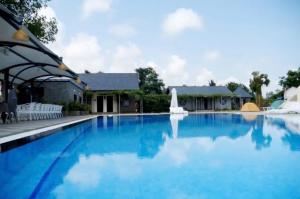 a large blue swimming pool with a fountain at Resort Mộc Hồ in Ho Tram