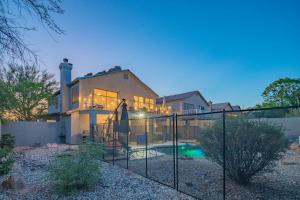 a house with a swimming pool in front of a fence at NEW Desert Daze, near Golf, Heated Pool+Spa, 12ppl in Scottsdale