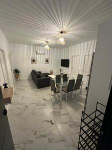 un soggiorno con un divano, un tavolo e delle sedie di Villa E y E a Novo Sancti Petri