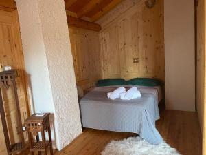 a bedroom with a bed with two pillows on it at Chalet Noemi in Lamon +6 photos