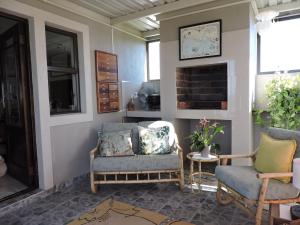 a living room with two chairs and a fireplace at Droom Verlore Vacation Home in Jeffreys Bay