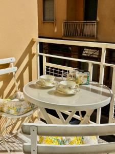 a white table with two cups and saucers on a balcony at La Casa di Anna, a un passo dal mare in Rapallo +17 photos