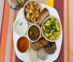 a plate of food with different types of food on it at Hotel Tropical International Near Delhi Airport in New Delhi
