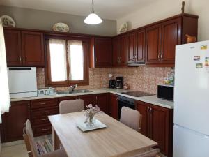 a kitchen with wooden cabinets and a wooden table at Fantasia Villas Deluxe "Selene" in Panormos Kalymnos