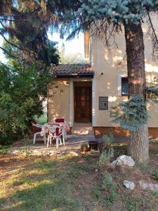 ein Haus mit einem Tisch, Stühlen und einem Baum in der Unterkunft Casa Bella Stup in Sarajevo