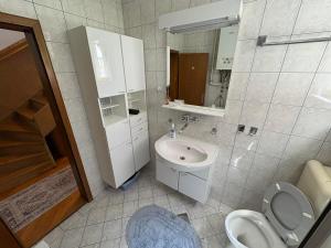 ein Badezimmer mit Waschbecken, Toilette und Spiegel in der Unterkunft Casa Bella Stup in Sarajevo + 15 Fotos