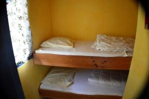 two bunk beds in a room with a yellow wall at Chalet #15, 4 pers, Domaine De Ribiere in Grospierres