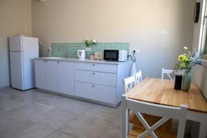 a kitchen with a table and a white refrigerator at ברקו בעמק in Bet HaShitta