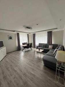a living room with a couch and a table at Schlosspark Apartment - Ferienwohnung in Schleswig