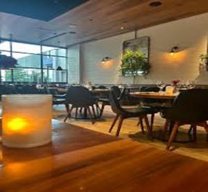 a restaurant with tables and chairs and a candle on the floor at Hotel Tropical International Near Delhi Airport in New Delhi