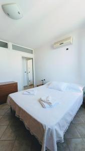 un letto bianco con due tovaglioli sopra di Cristiana Vacanze a San Benedetto del Tronto
