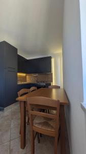 una cucina con tavolo e sedie in legno di Cristiana Vacanze a San Benedetto del Tronto