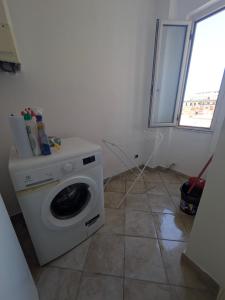 una lavanderia con lavatrice e finestra di Cristiana Vacanze a San Benedetto del Tronto